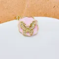 Nahaufnahme eines vergoldeten Schmetterling-Anhängers aus Kupfer mit pinker Emaillierung & Zirkonia. - Rosa Emaille Schmetterling Stil (2)