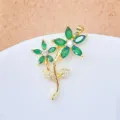 Nahaufnahme eines zarten, vergoldeten Blumenanhängers mit grünen Kristallblütenblättern. - Gold Doppelblumen Zweig Stil (1)