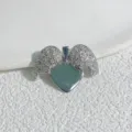 Detailaufnahme eines silberfarbenen Herzanhängers mit funkelnden Zirkonia-Flügeln. - Stil C Silber
