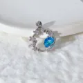 Primo piano dettagliato di un ciondolo a forma di pianeta argentato con pietra blu e zirconi. - Stile Pianeta Blu e Bianco (2)