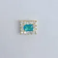 Primo piano del ciondolo in rame dorato con uno zircone blu vivido e pietre di contorno chiare. - Accessorio Quadrato Oro Blu (7)