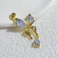 Detaillierte Nahaufnahme des vergoldeten Schleifenanhängers mit funkelnden Zirkoniasteinen. - Gold Drei Birnen Strass Schleife Stil