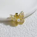 Nahaufnahme eines goldenen Schmetterlingsanhängers mit funkelnden Zirkonia und einer weißen Perle. - Perle Zentrum Schmetterling (6)
