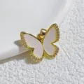Nahaufnahme Detailaufnahme eines vergoldeten Schmetterlingsanhängers mit weißen Zirkonia. - Gold Eingelegt Weiß Harz Halo Strass Schmetterling Stil