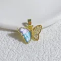 Nahaufnahme des vergoldeten Schmetterlingshängers mit schimmerndem Emailleflügel und Zirkonia. - Asymmetrisch Magisch Lila Emaille Eckig Strass Schmetterling Stil