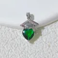 Detailed shot of a green heart crystal graduation cap pendant necklace, elegant and unique. - Silver-Green Heart