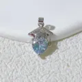Close-up of graduation cap heart rhinestone pendant, delicate silver metal necklace detail. - Silver-White Rhinestone