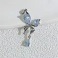Pendentif nœud argenté élégant orné de cristaux étincoyants bleu clair en forme de goutte. - Argent