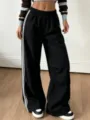 Pantaloni lunghi larghi da donna con vita elastica e bande laterali sportive ed eleganti. - Taglia S / Pantaloni e gonne / Nero