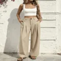 Detailed view of high-waisted pleated wide-leg pants in casual khaki style, outdoor scene. - XL / Bottoms / Apricot