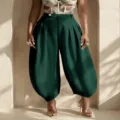 Dark green high-waisted lantern pants detail showing pleated design and harem trousers fit - S / Bottoms / Green