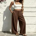 Detail view of women's high-waisted pleated wide leg casual trousers in stylish brown. - XL / Bottoms / Coffee