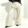 Detailed view of women's high-waisted wide leg trousers with elegant drape and clean finish. - S / Bottoms / Apricot