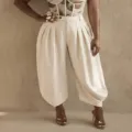 Detail view of high waisted pleated lantern trousers in cream color with elegant draped fit. - S / Bottoms / White