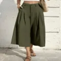 Detail view of olive green high-waisted cropped wide leg trousers with drape fabric. - S / Army Green