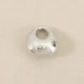 Silver metal textured fortune bag bead detail, perfect for DIY jewelry crafting and charm bracelets. - Silver