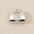 Gros plan détaillé du mini pendentif cadenas sac à main argenté avec symbole de chance. - Argent