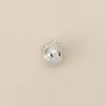 Detailed shot of a small silver metal charm pendant with intricate design for DIY jewelry. - Silver