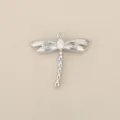 Detailed close-up view of a silver plated metal dragonfly pendant with sparkling zircon stone. - Silver