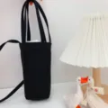 Tragbare schwarze Segeltuch-Tassenhülle mit Schultergurt, minimalistisches einifarbiges Design. - Schwarz Umhängetasche Stil