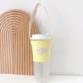 Minimalistische pastellfarbene Kaffeetasse-Hülle aus Leinen mit tragbarem Griff für unterwegs. - Hellgelb