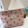 Gros plan détaillé de la trousse de toilette rose en velours côtelé avec motif ananas. - Ananas Rose Clair