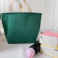 Dark green canvas lunch bag with cream handles, practical bento tote for daily work commute. - Avocado Green