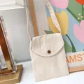Detailaufnahme der minimalistischen, beige Canvas Umhängetasche mit praktischem Überschlag. - Aprikose