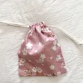 Rosa blumiger Kordelzug Aufbewahrungsbeutel Detail mit Stofftextur und Kirschblütendruck. - Rosa Kirschblüte