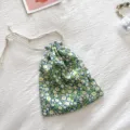 Detailaufnahme des floralen Kordelzug-Stoffbeutels mit blauem Muster und sauberer Naht. - Grünes Blumenmuster