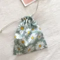 Detailaufnahme des süßen Gänseblümchen Kordelzug Beutels, tragbare Kosmetiktasche aus Stoff. - Hellgrünes Gänseblümchen