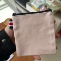 Pink canvas coin purse with zipper closure and striped side tab for daily travel storage. - Light Pink