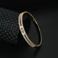 Elegant double-row pavé zirconia bracelet with natural shell accent detail, luxury fashion jewelry. - Gold