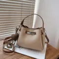 Élégant sac seau beige avec poignée marron, fermeture métallique chic et charmant pendentif. - Beige avec Pendentif