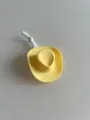 Dettaglio del piccolo cappello da cowboy giallo, accessorio per bambole in plastica elastica. - Laccio sottogola bianco / Giallo