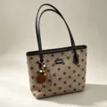 Brown polka dot tote bag with black handles and stylish charm pendant for daily commute. - Khaki