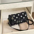Vintage zwart-witte polkadot schoudertas met stijlvolle lederen riem en metalen gesp. - Zwart