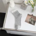 Calcetines grises de media caña en malla con bordado de perrito y ribete de volantes con lunares. - Talla única / Gris
