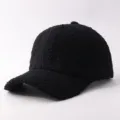 Close-up detail of black sherpa baseball cap, cozy fuzzy plush texture, warm winter hat. - Adjustable / Black