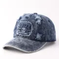 Primo piano di un berretto da baseball in denim delavè con ricamo frontale e dettagli strappati. - Regolabile / Brooklyn Denim Distressed-Blu Scuro