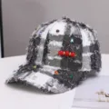 Zwart-witte tweed honkbalpet met kleurrijke strass-steentjes en decoratieve rode parelbroche. - Eén maat / Wit