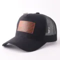 Detaillierte Nahaufnahme der schwarzen Trucker Cap mit braunem amerikanischem Flaggen Patch. - Flaggen-Patch-Stil / Schwarze Wildleder Flagge Mesh Kappe