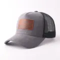 Nahaufnahme der grauen Wildleder-Truckercap mit atmungsaktivem Mesh-Einsatz und Flaggen-Patch. - Flaggen-Patch-Stil / Graue Wildleder Flagge Mesh Kappe