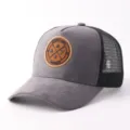 Detail van grijze suède mesh truckerpet met stijlvolle ronde patch en ademende achterkant. - Grijs Suède Ronde Patch Mesh Pet