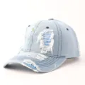 Light blue distressed denim baseball cap with paint splatter details and ripped frayed holes. - Adjustable / Dotted Graffiti Ripped Denim - Light Blue