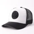 Zwarte en witte truckerpet met ademende mesh achterkant en zacht suèdelook voorpaneel. - Wit & Zwart Suède Ronde Zwarte Patch Mesh Pet