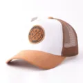 Detailopname van de bruine suède en witte mesh truckerhat met het patchontwerp aan de voorkant. - Wit & Khaki Suède Ronde Patch Mesh Pet
