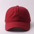 Vista detallada de una gorra de béisbol roja lisa de algodón, con visera ancha y copa estructurada. - Ajustable / Parte Superior Suave Lisa / Burdeos