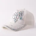 Gros plan sur l'élégante casquette blanche en dentelle avec papillon en strass étincelant. - Réglable / Style Papillon en Strass Dentelle / Beige