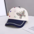 Vista detallada de gorra de béisbol beige y azul con mariposa de diamantes de imitación y cristales. - Ajustable / Mariposa Colorida / Bloques Beige Y Azul Marino